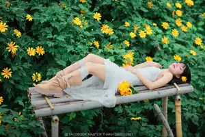 Graceful Young Woman in White Dress Amidst Vibrant Yellow Flowers 1000026997-9
