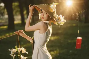 Serene Vietnamese Beauty in White Ao Dai with Lilies: A Golden Hour Portrait 1000025192-2