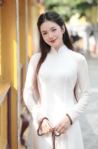 Elegant Vietnamese woman in traditional white Ao Dai, showcasing graceful beauty amidst ancient architecture.-9