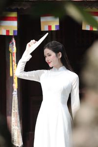 Elegant Vietnamese woman in traditional white Ao Dai, showcasing graceful beauty amidst ancient architecture.-8