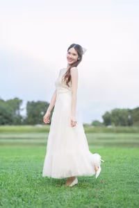 XVG No.19: Radiant Bride: Beautiful Woman in Elegant White Gown with a Joyful Smile in Lush Green Setting.-4