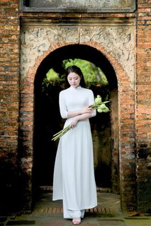 Elegant Vietnamese Woman in Traditional White Ao Dai, Gracing an Ancient Pathway | 1000017528-3