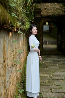 Elegant Vietnamese Woman in Traditional White Ao Dai, Gracing an Ancient Pathway | 1000017528-1
