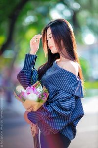 Elegant Beauty Charming Vietnamese Girl with Fresh Flowers on Street Captivating Street Fashion Style-1