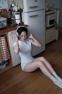Young Woman Relaxing with Headphones & Music in Cozy Kitchen: Serene Home Lifestyle Moment-4