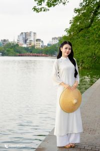 Elegant Vietnamese girl in traditional white Ao Dai by the lake, embodying cultural beauty-2