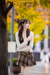 Young Asian Girl in Plaid Skirt Embracing Autumn Foliage-2