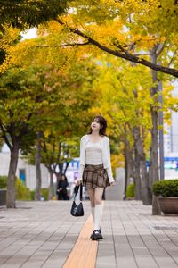 Young Asian Girl in Plaid Skirt Embracing Autumn Foliage-16