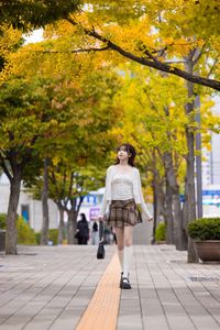 Young Asian Girl in Plaid Skirt Embracing Autumn Foliage-14