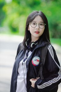 Radiant Youth: Girl in Uniform Playfully Blowing Bubbles in Lush Greenery 1000019736-4