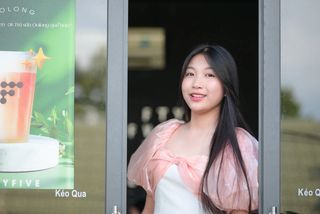 Radiant smile of a young, elegant Vietnamese girl in a pink and white dress.-0