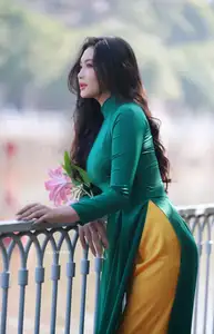 Vietnamese Grace: Elegant Woman in Green Ao Dai with Pink Lotus Flower 1000025232-1