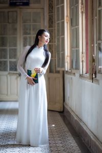 Graceful Vietnamese Girl in White Ao Dai by Window, Celebrating Traditional Beauty-11