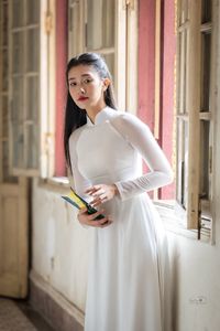 Graceful Vietnamese Girl in White Ao Dai by Window, Celebrating Traditional Beauty-6
